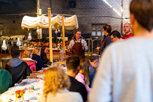 Die Gruppe lauscht den Erklärungen des Küchenchefs während eines Grill-Workshops bei Buiten Eten in Someren